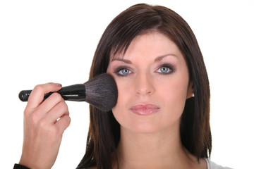 Portrait d'une femme se maquillant les joues
