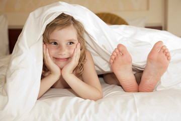 little girl and leg of mother under cover