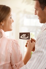 Happy parents with ultrasound baby photo