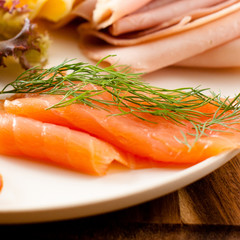Close-up of smoked salmon and ham in background