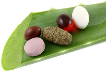 comprimés, capsules... sur feuille d'aloe vera, fond blanc