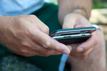 Hands of Man Texting on Smartphone