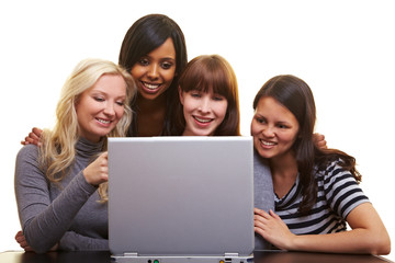 Vier Frauen schauen auf einen Laptop