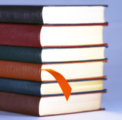 An Orange Bookmark and Six Leather Bound Books