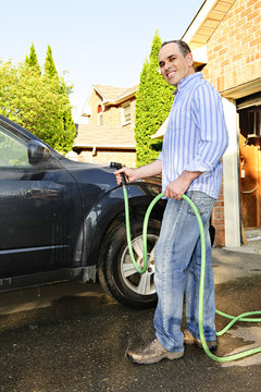 Man Washing Car On Driveway