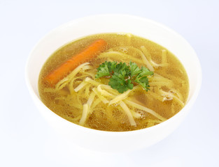 Chicken soup with macaroni and carrots with parsley in a bowl