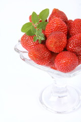 Strawberries in a cup decorated with a lemon balm twig
