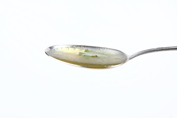Chicken soup with macaroni decorated with parsley on a spoon