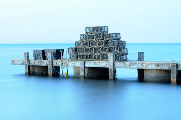 A pile of lobster pots, stacked on a jetty