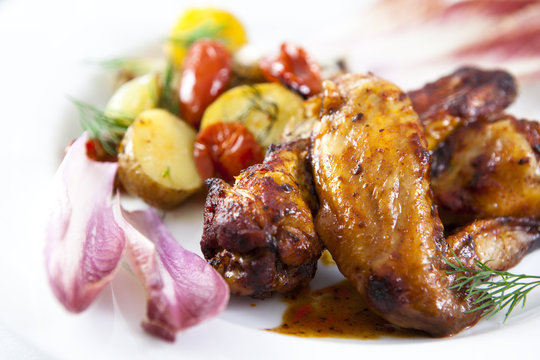 Roast chicken wings with baked vegetables and chicory