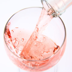 Pink wine being poured into a wine glass