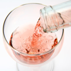 Pink wine being poured into a wine glass © teine