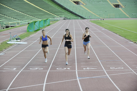 girls running on athletics race track © .shock