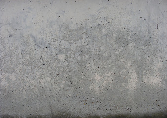 gray pink worn concrete wall with some dirt at the bottom