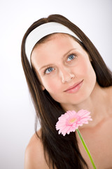 Beautiful woman holding gerbera daisy flower with white headband