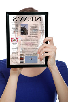 Woman holding a touchpad pc, reading a newspaper