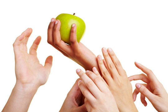 Viele Hände greifen nach Apfel