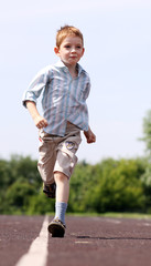 little boy runs in a summer park