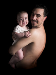 baby boy and his father, black background