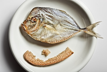 Salted moonfish with crust of bread on white plate