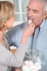 couple de seniors mangeant des guimauves