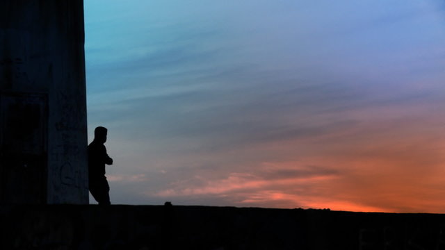Alone man standing towards sunset/sunrise. HD 1080p.