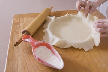 Covering Pie Pan With Dough On A Cutting Board