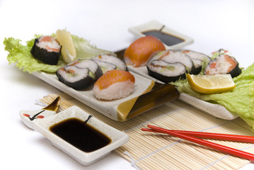 Sushi with chopsticks against white background.