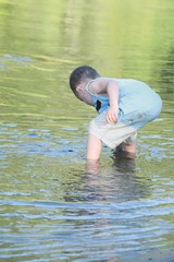 A young boy playing in the shallow water