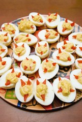 A Plate Of Deviled Eggs In The Shape Of Devil's Faces