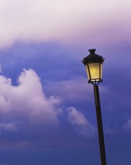 Lamp post against cloudy sky