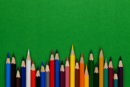 multicolored pencils lie on a green background