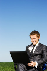 Successful businessman in the field, with glasses