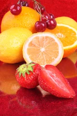  Kleurrijk vers fruitassortiment op rood © VenisM