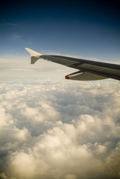 A passengers view of a plane's wing high above the clouds.