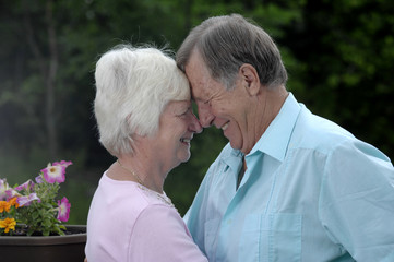 Senior couple shares tender moment in their garden.