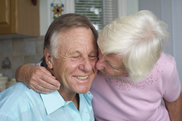 Senior couple shares tender moment in their kitchen.