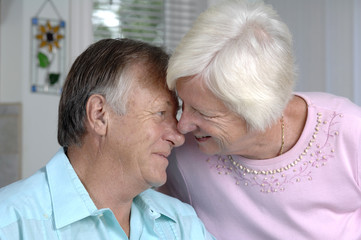 Senior couple shares some tender moments in their kitchen.