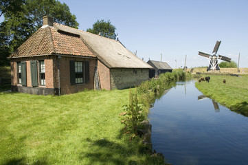 Old house vith canal and windmill