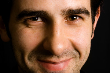 Fototapeta premium Close up portrait of an young attractive man on a black backgrou