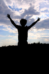 man silhouette jumping at cloudy background