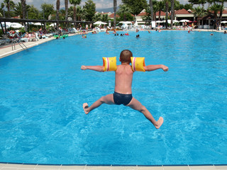 boy jumping in swimming pool