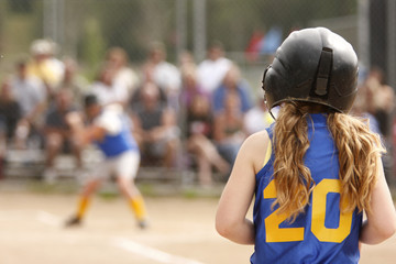 First base coach watching teammate up to bat