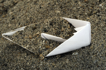 Barca di carta nella sabbia