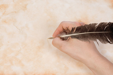 hand with feather at paper