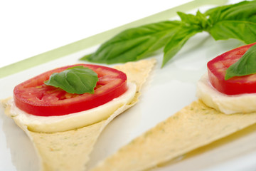 Fototapeta na wymiar Mozzarella, tomato, basil, on crocantini (Selective Focus)
