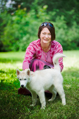 Naklejka na ściany i meble beautiful girl with puppy of husky in park