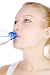 beautiful girl drinks mineral water from plastic bottle.