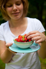 Girl holding a bowl of strawberries