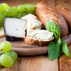 Cheeses with baguette,grapes and fresh herbs